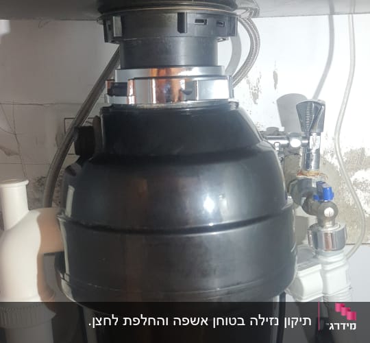 מתקן טוחן אשפה מתחת לכיור עם צינורות חיבור